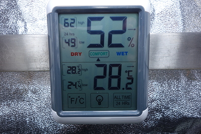 Ein digitales Hygrometer und Thermometer zeigt eine Luftfeuchtigkeit von 52% und eine Temperatur von 28,2°C an.