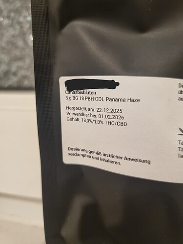 Nahaufnahme einer Verpackung mit Cannabisblüten, auf der die Sorte 'Panama Haze' und weitere Details wie Herstellungsdatum und THC/CBD-Gehalt aufgeführt sind.