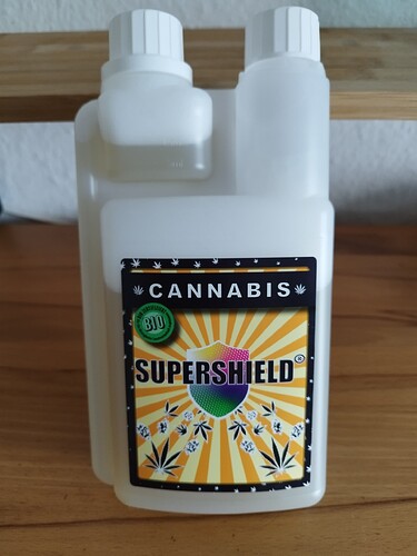 Eine weiße Plastikflasche mit einem Etikett, auf dem "CANNABIS SUPERSHIELD BIO" steht.