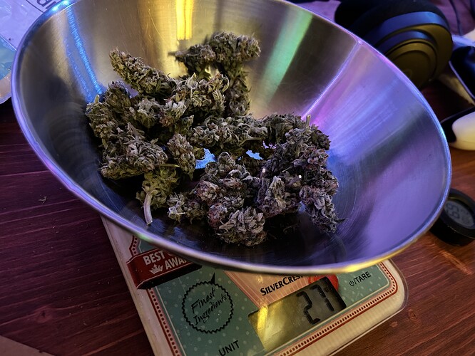 Cannabis-Buds in einer Metallschüssel auf einer digitalen Küchenwaage.