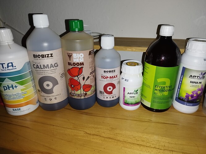 Mehrere Flaschen mit Düngemitteln und pH-Regulatoren, darunter Biobizz Calmag, Biobizz Top-Max, Bio Hesi Bloom, Terra Aquatica pH+ und Aptus Super-PK.