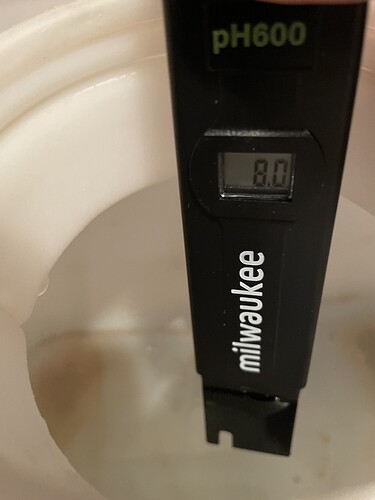 Ein pH-Messgerät von Milwaukee mit der Anzeige "8.0" in einer weißen Flüssigkeit.