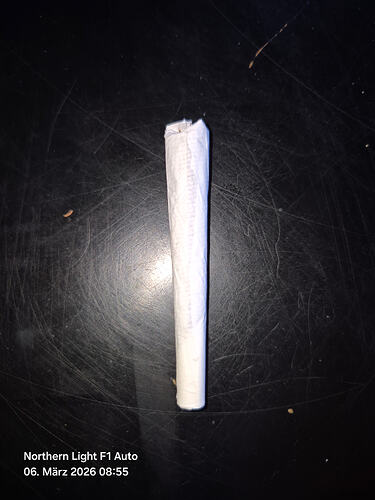 Ein fertig gedrehter Joint auf einer dunklen Oberfläche.