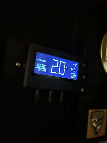 Ein digitales Display eines Klimacontrollers zeigt eine Temperatur von 20 Grad Celsius und eine Luftfeuchtigkeit von 61 Prozent an.
