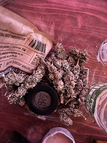 Cannabis-Buds in einem Glas mit einem Boveda-Pack und einem Hygrometer zur Kontrolle der Luftfeuchtigkeit.